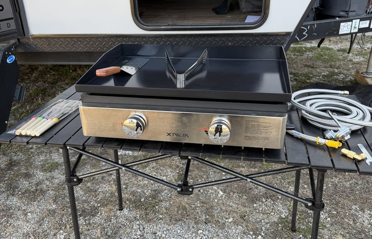 The camper offers a propane hookup for the flat top grill. Accessories included. Marshmallow/hotdog roasting sticks included.