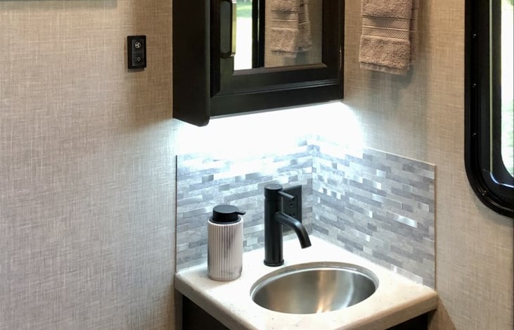 EXTRA half-bath off of main cabin with toilet and sink.