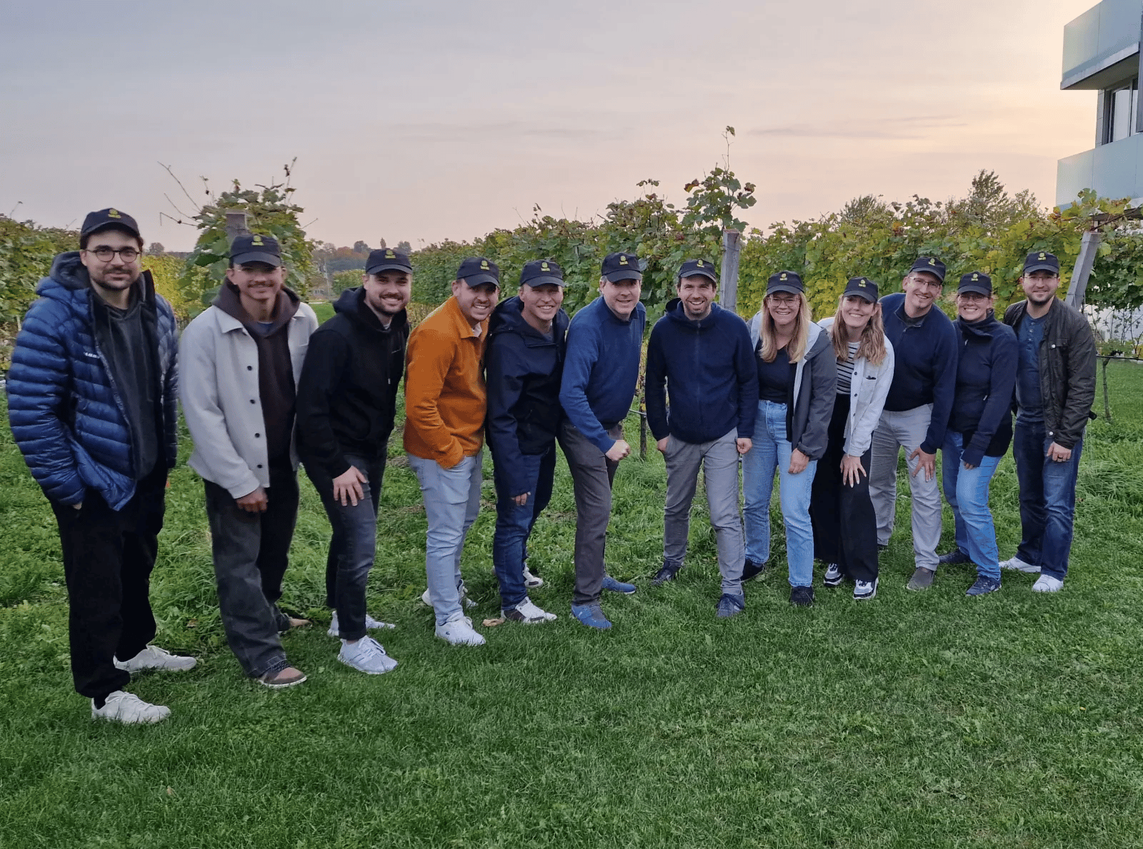 Das AITI-Team im Weinberg auf Zypern — jeder mit Cap, gemeinsam am Sunset-Treffen.