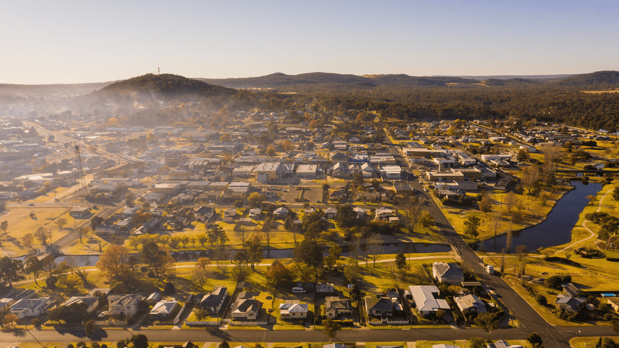 Vista aérea de una pequeña ciudad o pueblo en la región de Darling Downs and South West en Queensland, Australia, rodeada de colinas y naturaleza en un día soleado.