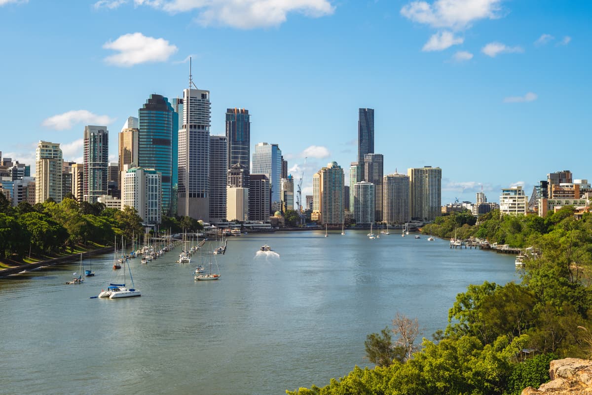 Vista panorámica del río Brisbane con barcos y rascacielos de la ciudad, un destino popular para estudiantes internacionales de TAFE Queensland en Australia.
