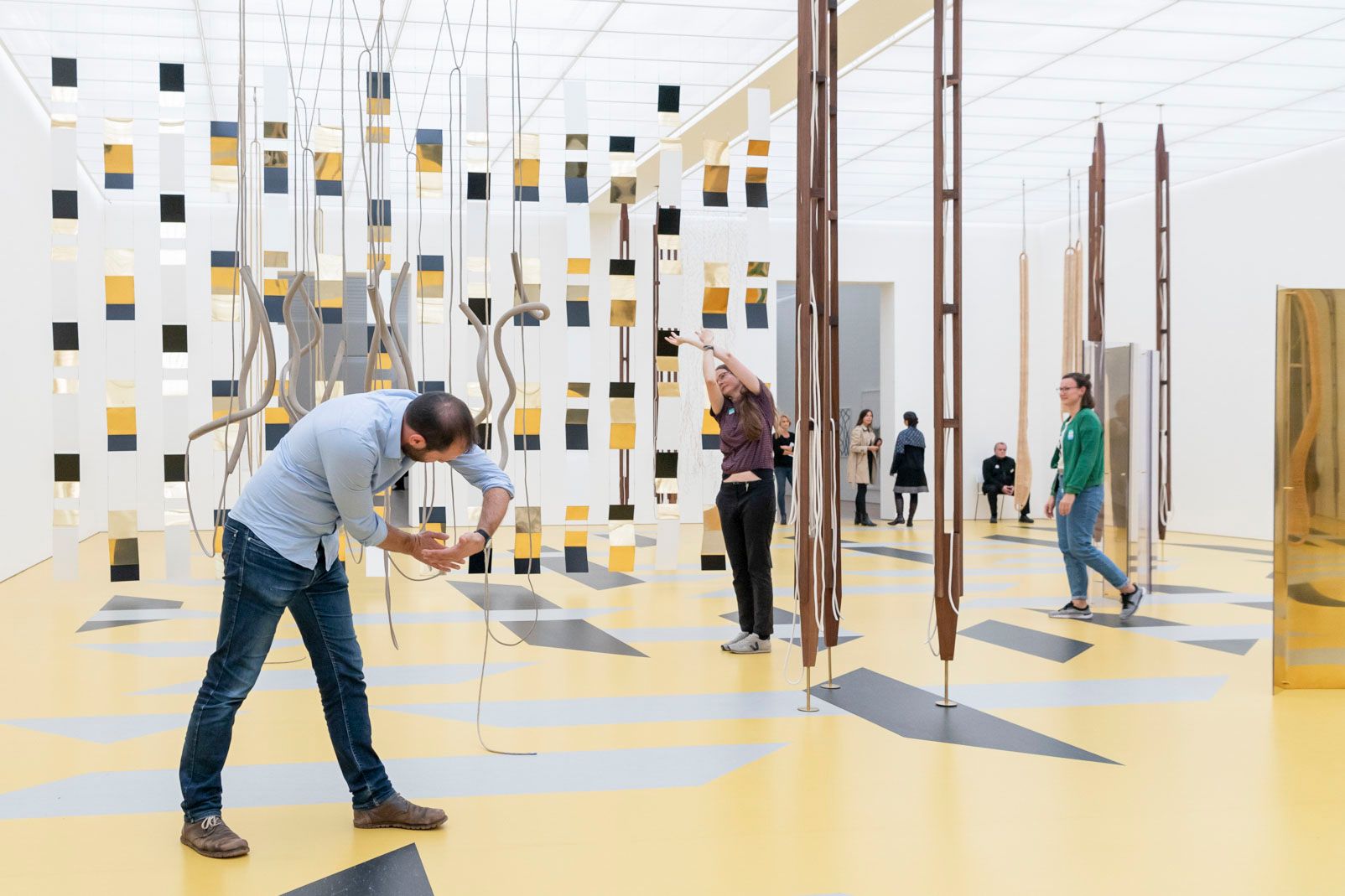 Menschen agieren mit der Kunst in einem Ausstellungssaal.