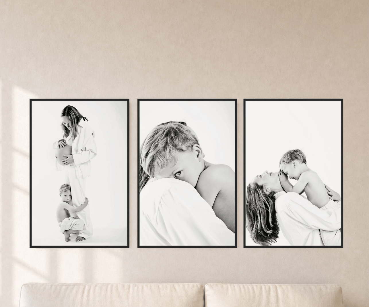 Three framed black and white portraits hung in a row above a wood console