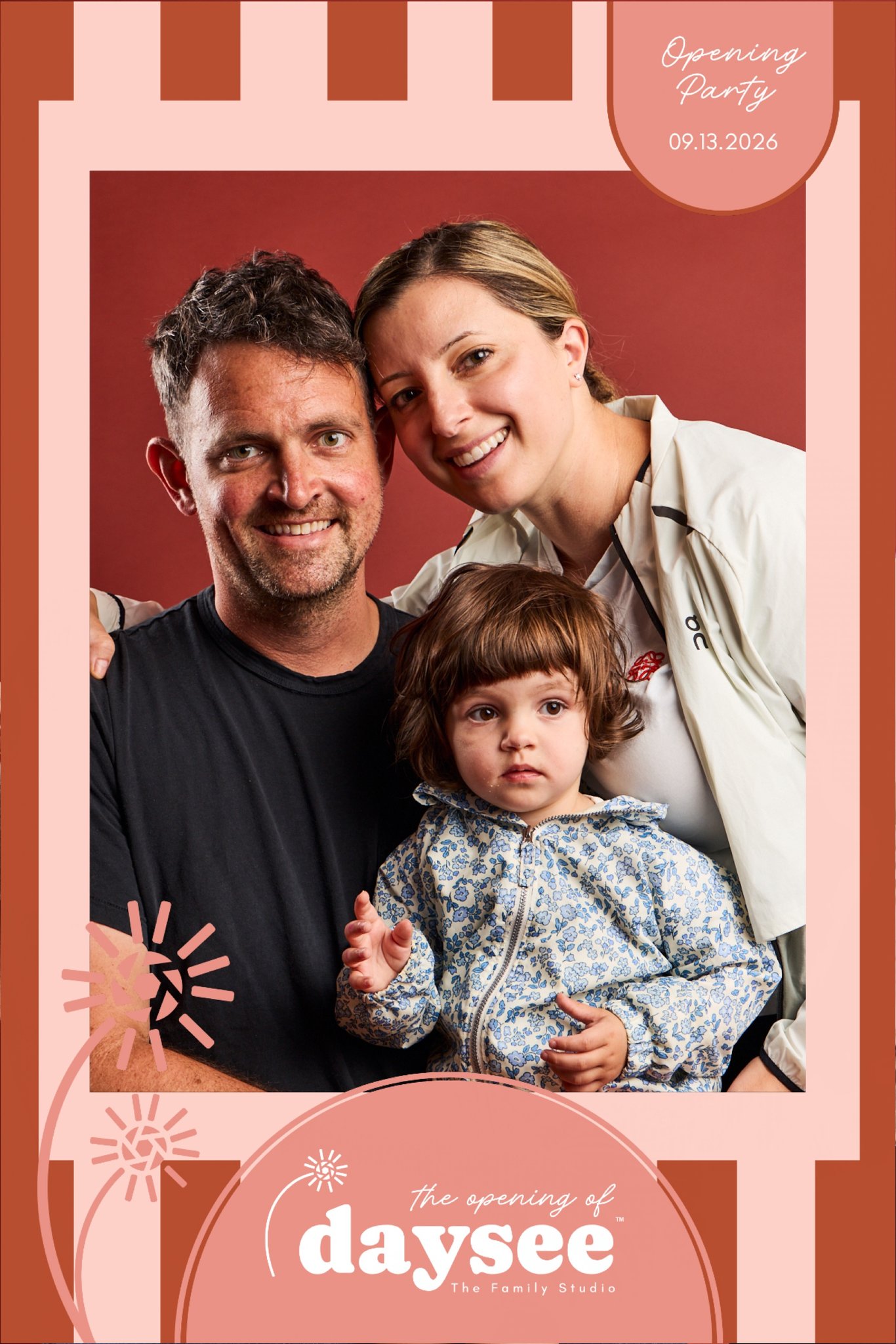 A family of three in an instant-print party frame