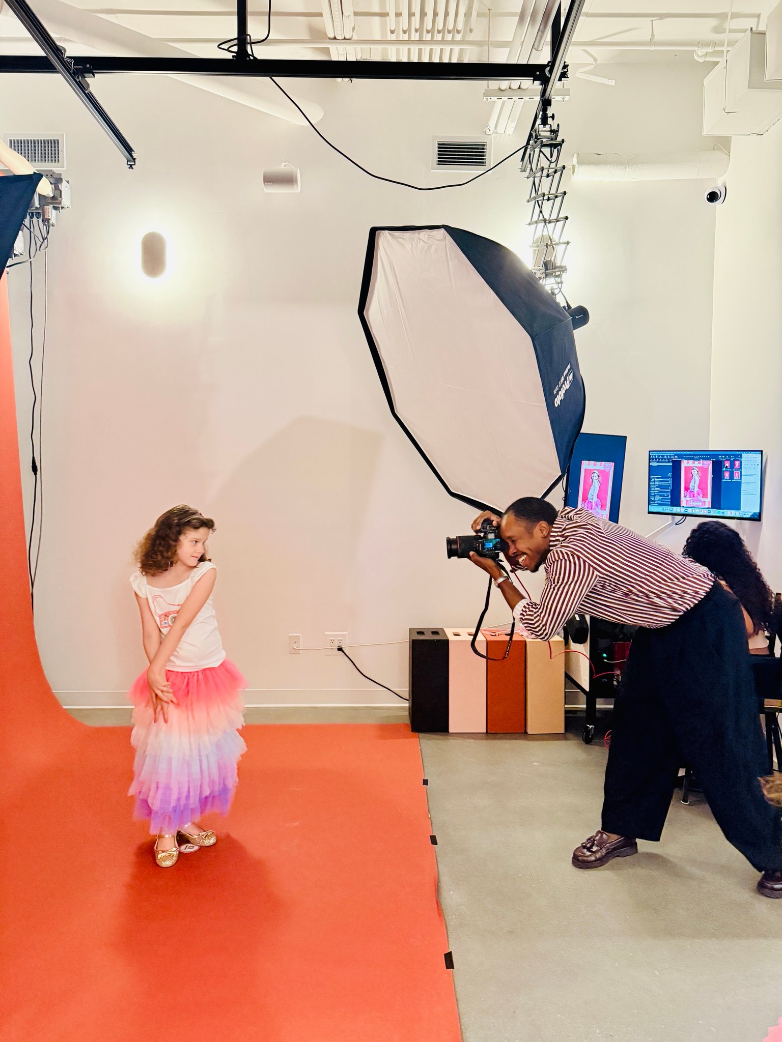 A photographer shooting a girl in a tutu on the studio sweep