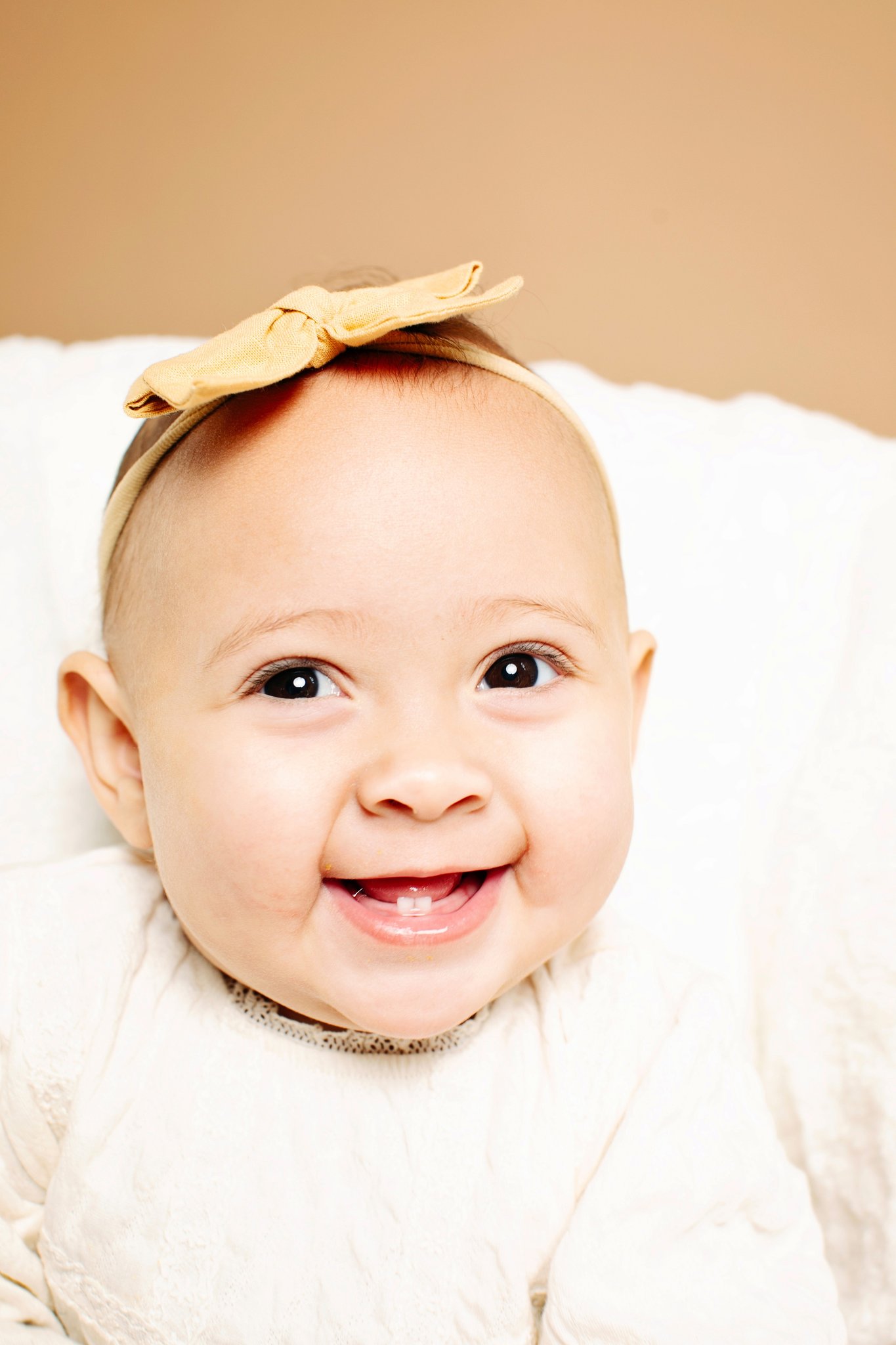 A smiling baby with two bottom teeth