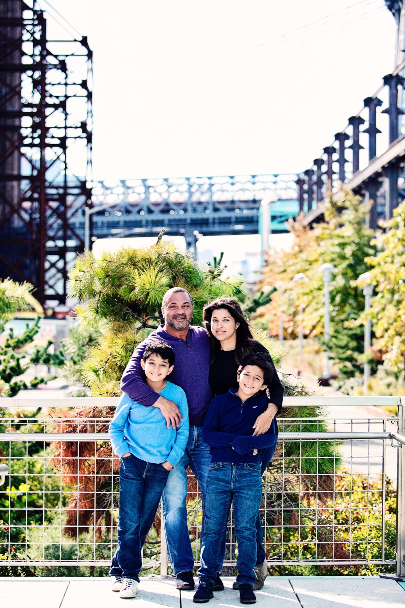 A family of four on Domino Park’s elevated walkway with the Williamsburg Bridge behind them