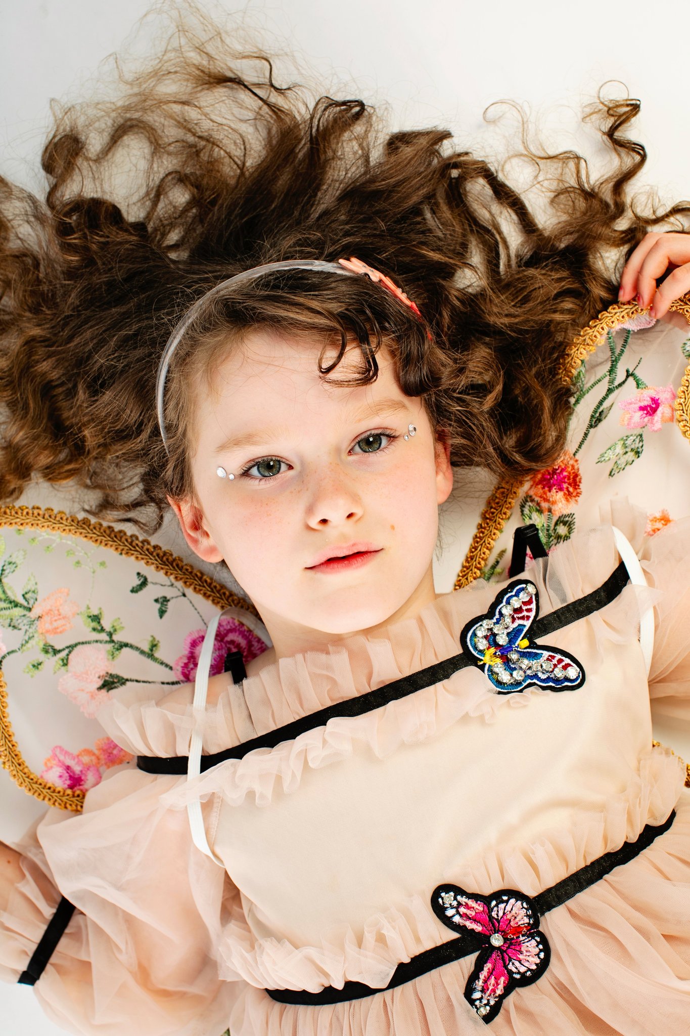 A girl in a fairy dress lying with her hair fanned out