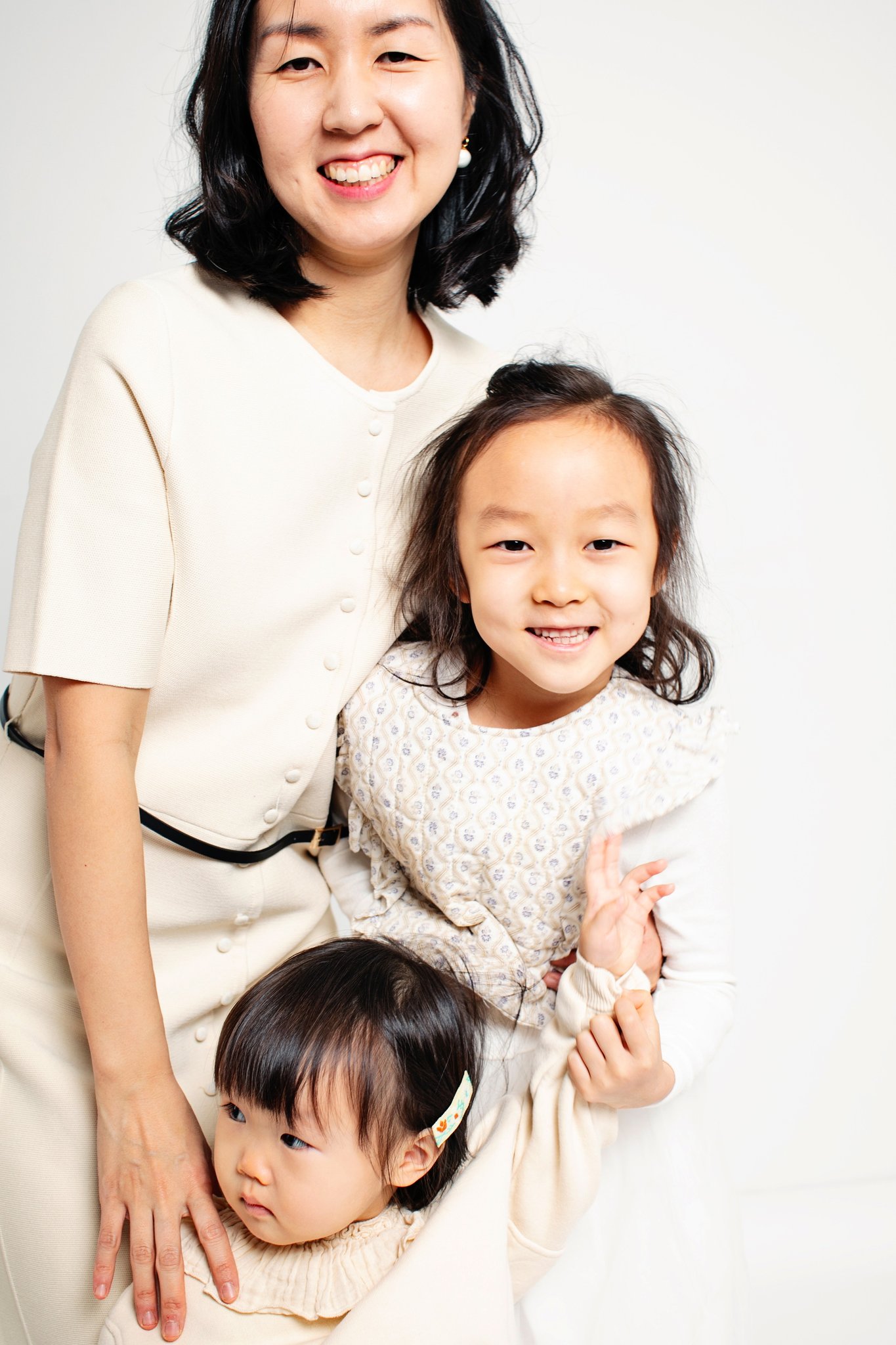 A mother with her two daughters on a white backdrop