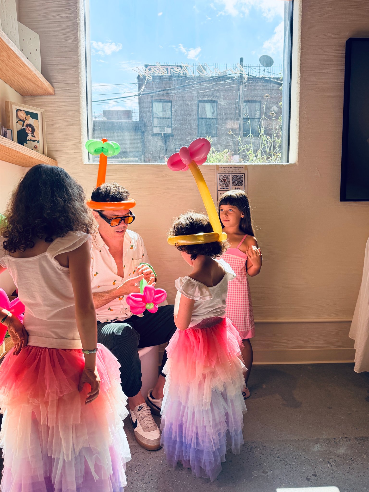 Girls in tutus with balloon crowns at a studio birthday
