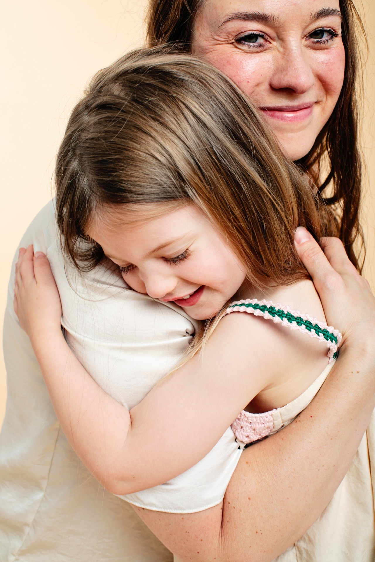 A girl hugging her mother tightly