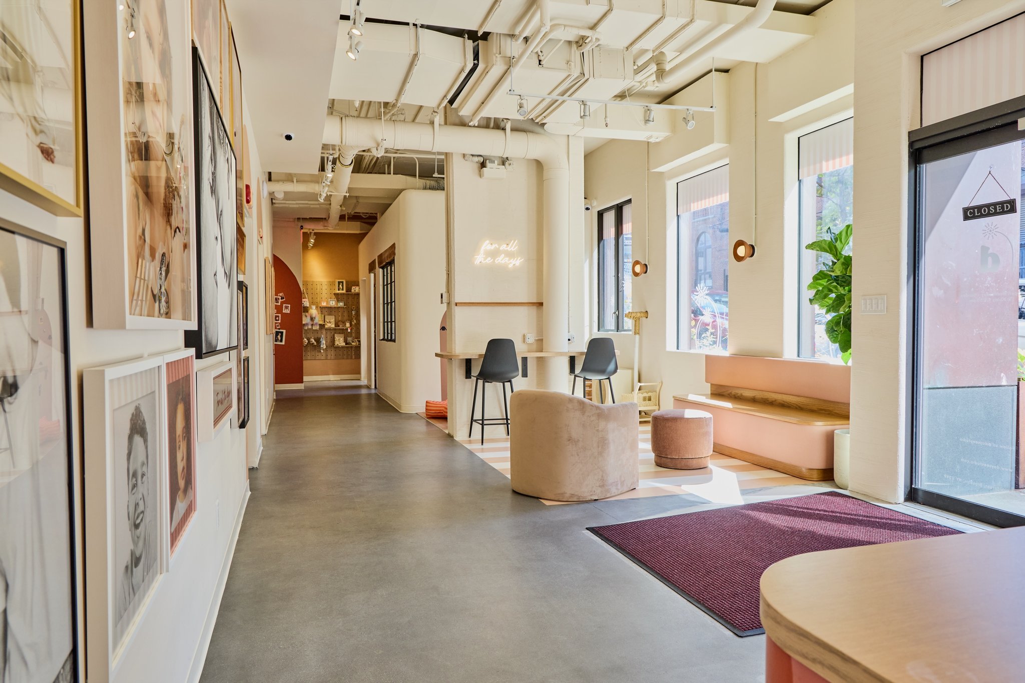 The Daysee lounge and gallery hallway, with pink banquette seating and the for all the days neon