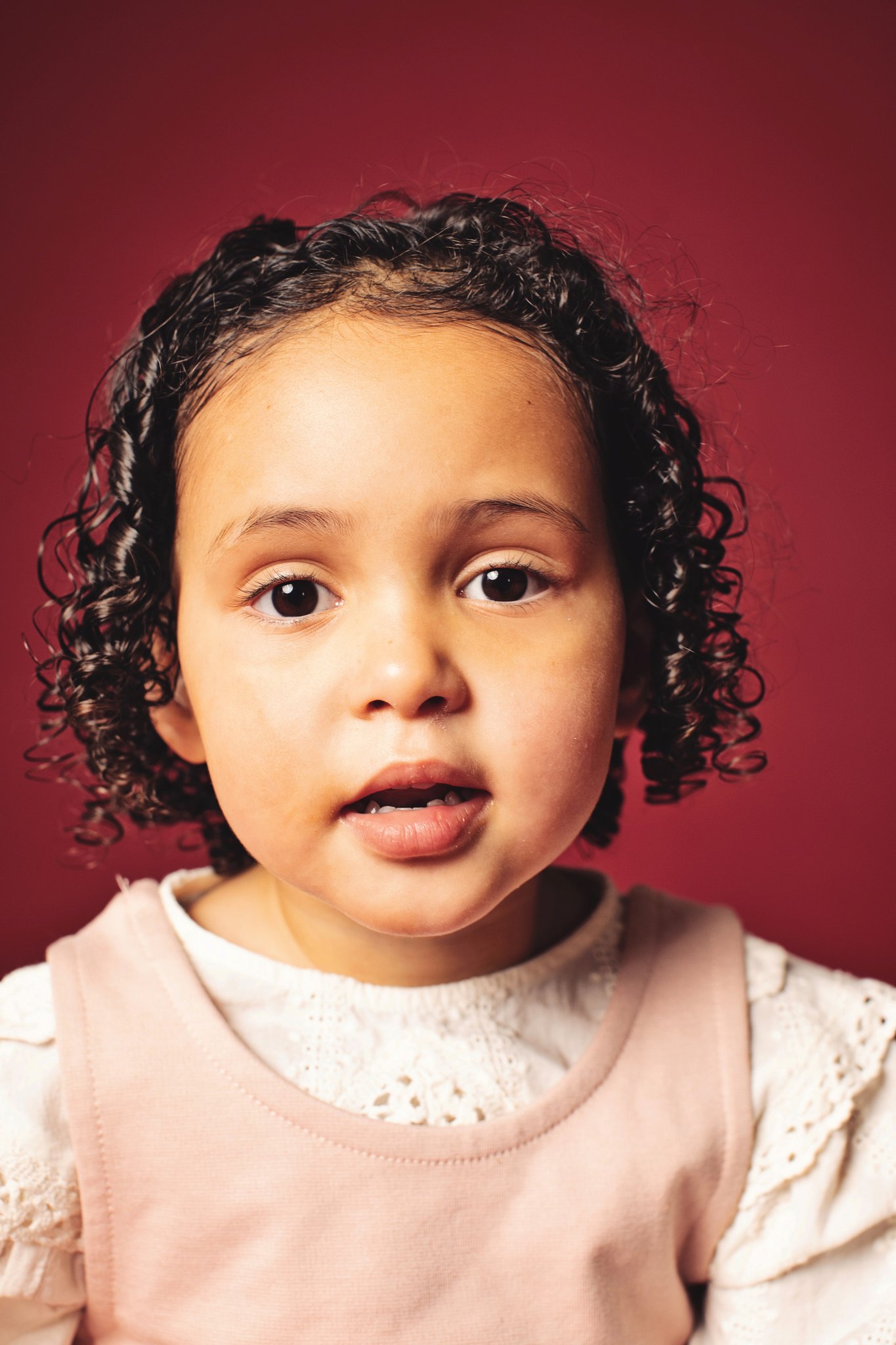 A girl looking at the camera on a wine backdrop