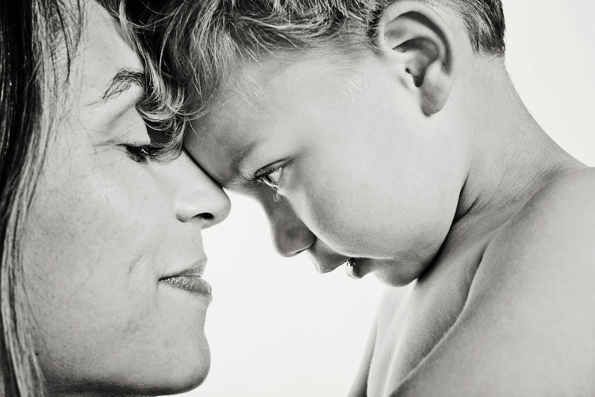 A mother and her son forehead to forehead, in black and white