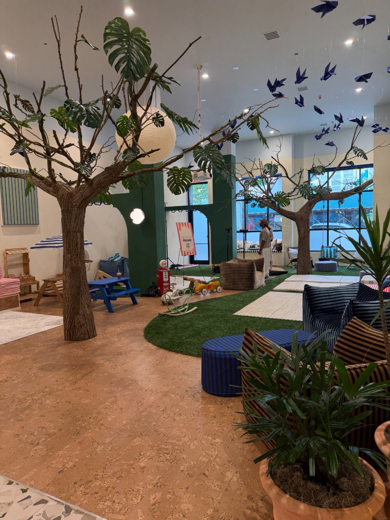A Daysee pop-up set inside a venue with trees, play areas and signage