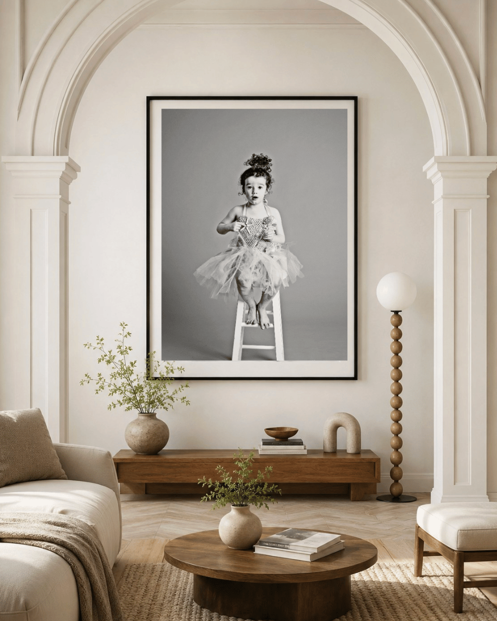 A large framed black and white portrait above a console in a light living room