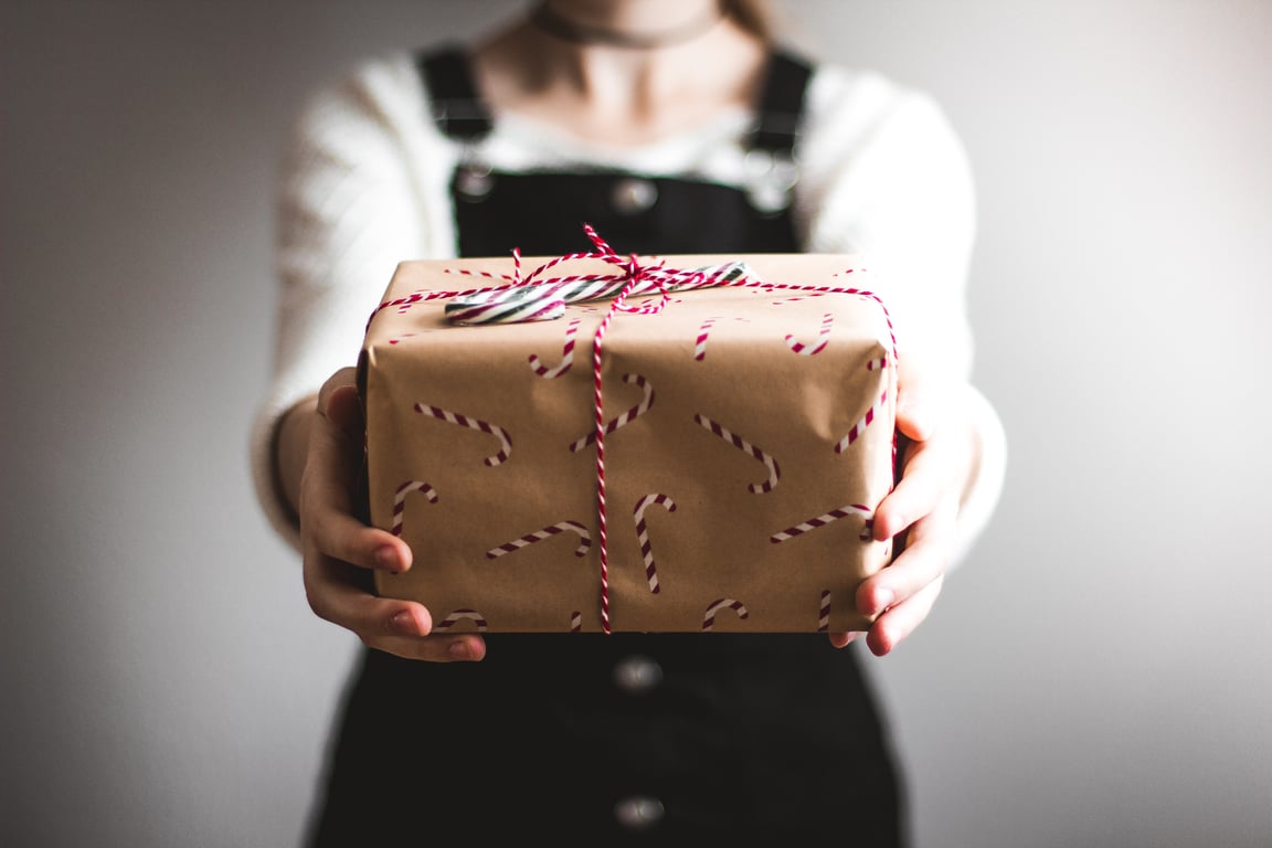 Person offering a present to a hotel guest