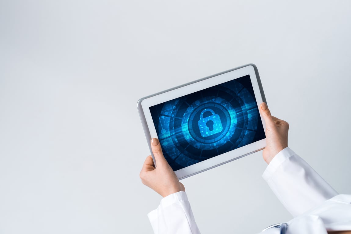 Hands holding a tablet with a digital lock symbol representing data protection
