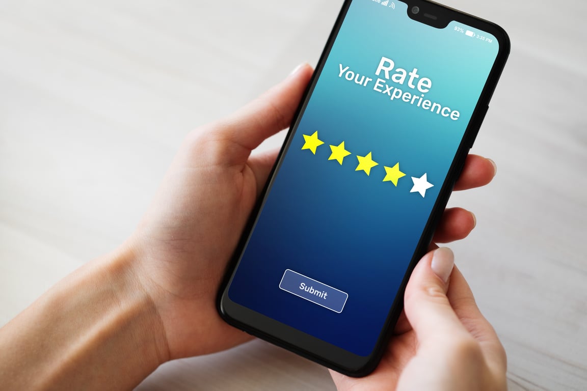 Person holding smartphone displaying hotel rating and review screen