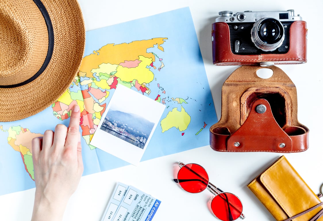 Travel planning equipment and accessories including map, camera, and sunglasses