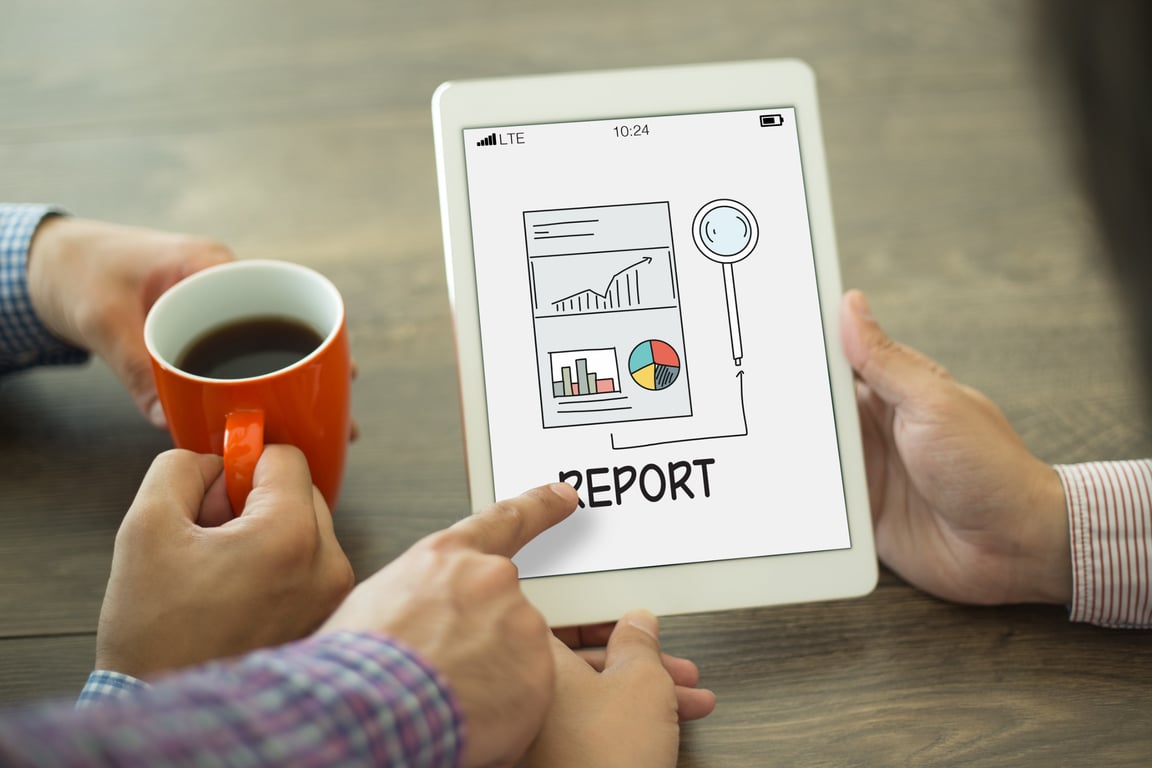 Person using a tablet to review hotel performance and upsell rate reports