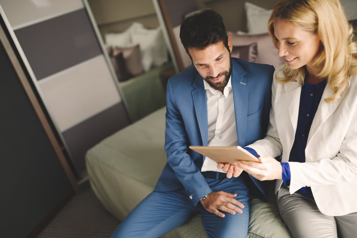 A couple reviewing hotel loyalty program perks on a tablet