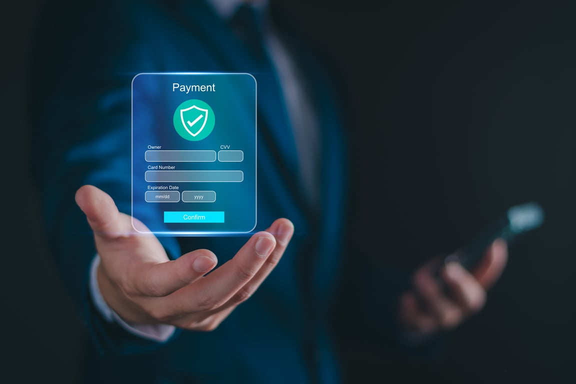 Business professional holding a holographic secure payment interface with shield icon, representing advanced hotel payment processing technology