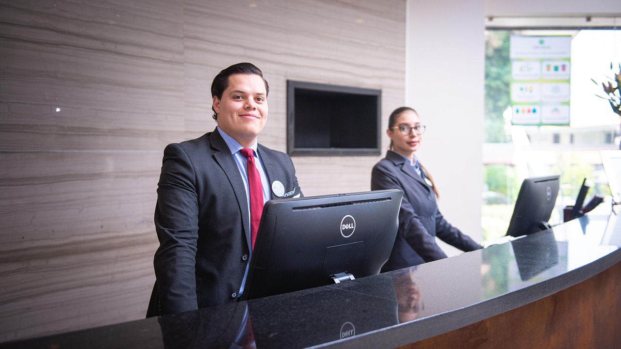 Concierge using guest communication software with hotel guests at the front desk.