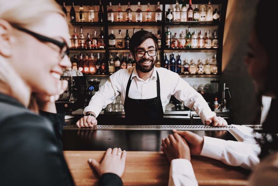 Hotel bartender engaging guests with personalized service offers