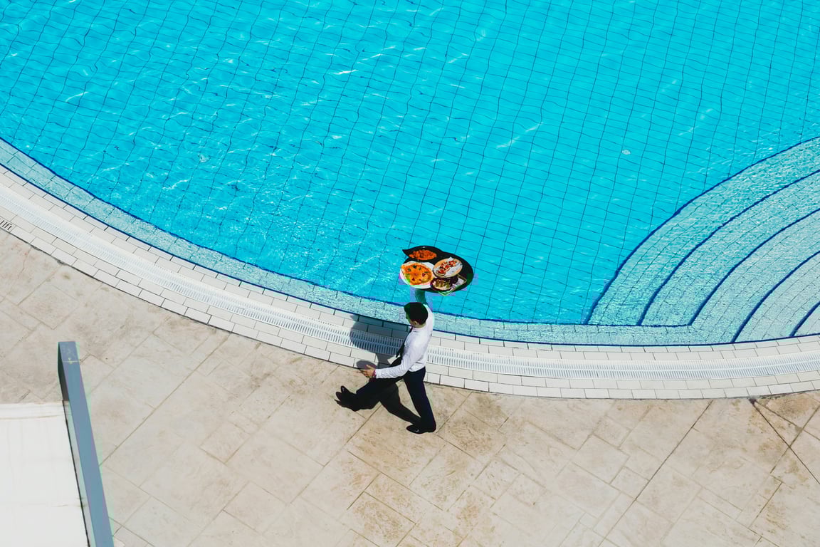 Man carrying food tray to hotel guests in a Hilton hotel