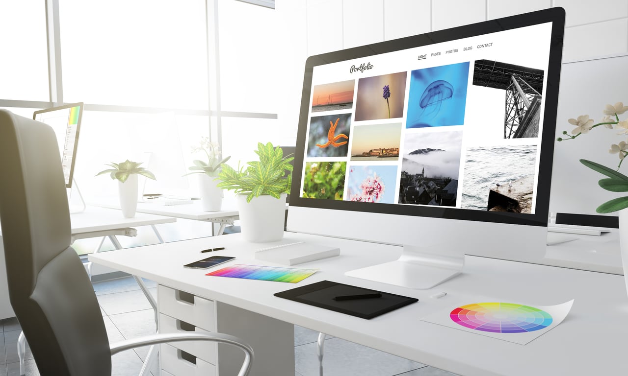 Modern desk setup with a computer displaying a hotel website portfolio.