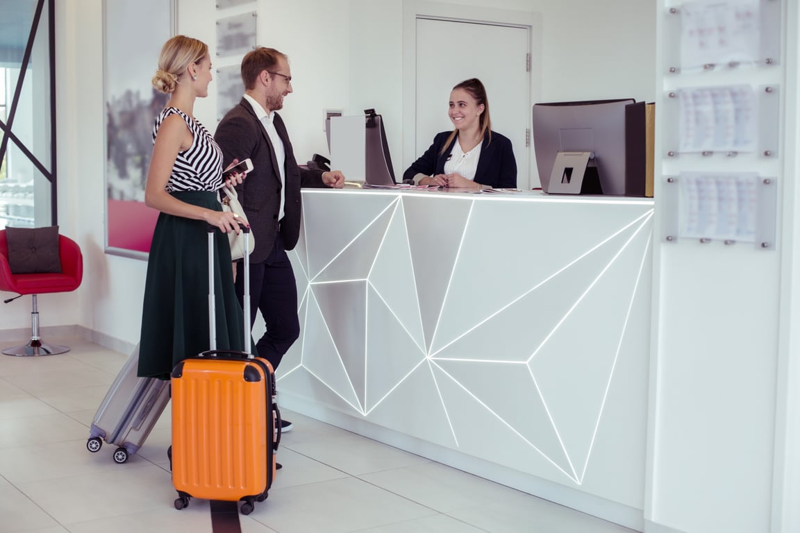 Receptionist at hotel discussing pre-arrival upsell options with guests