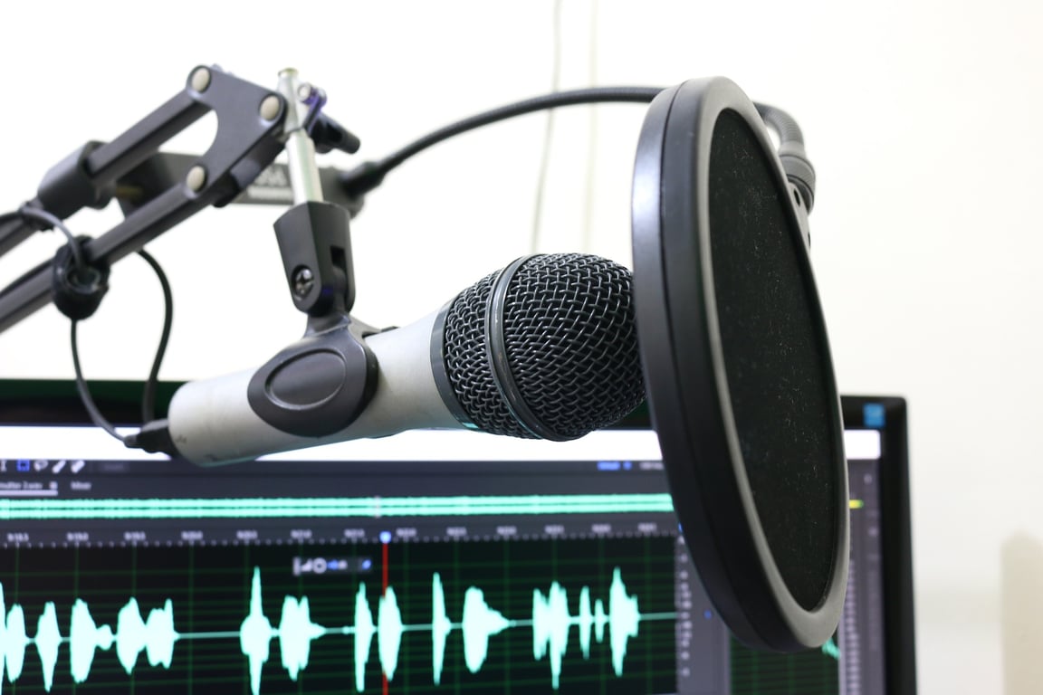 A podcast mic connected to a laptop that’s recording.