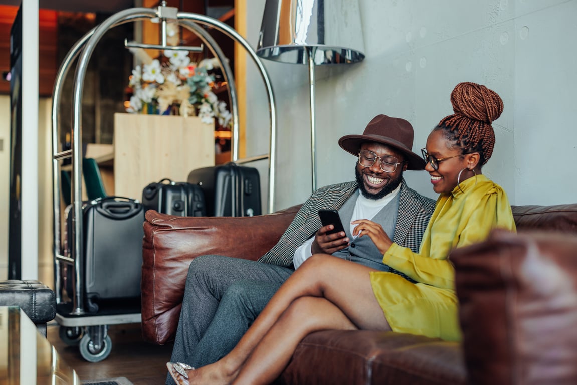Two guests exploring additional service options on a mobile device during hotel check-in.