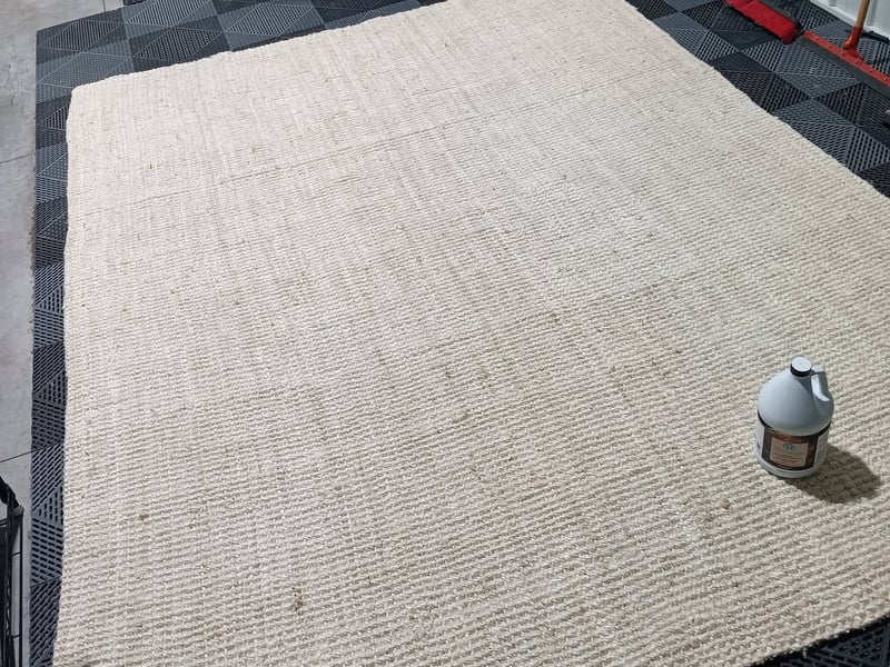 The same beige area rug washed clean in-shop, the stain lifted and the fiber brightened