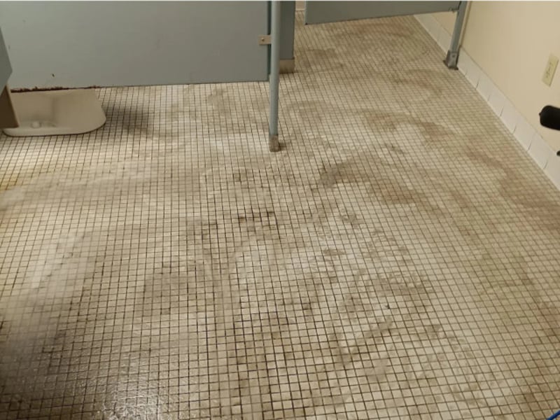 Dirty, stained commercial restroom tile and grout before cleaning by Andrew's Pro Clean in Owatonna, MN