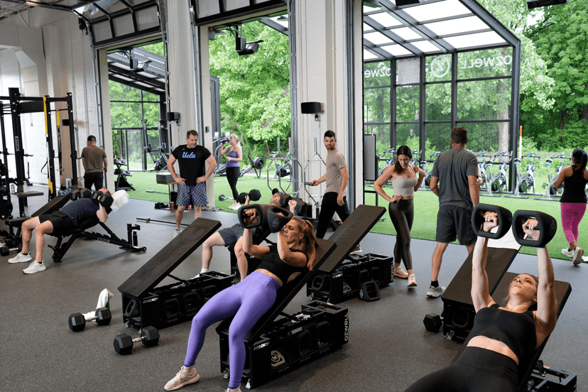 Members lifting dumbbells on the open-air training floor at Ozwell Fitness in Carmel