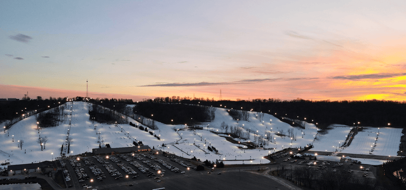 Lit ski and snowboard slopes at dusk at an Indiana winter resort