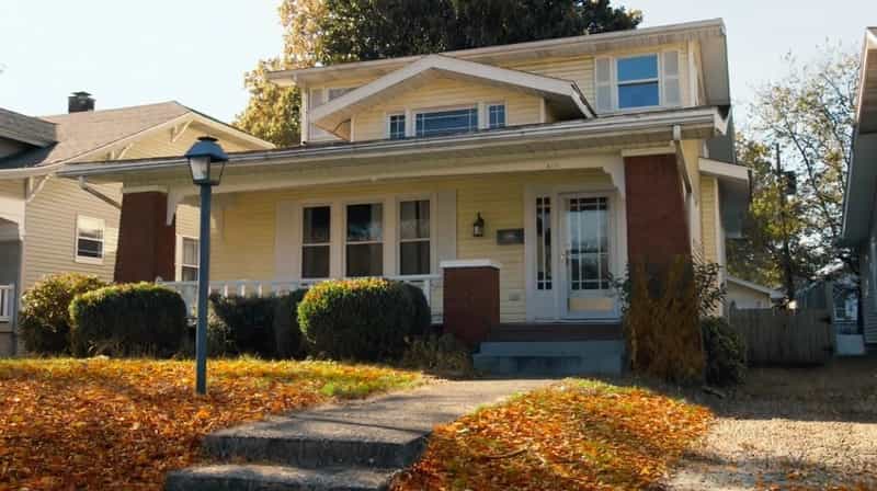 The pale yellow two-story house on South Runnymeade Avenue in Evansville, Indiana used for exterior shots of the Conner family home on Roseanne, with fallen autumn leaves across the front lawn
