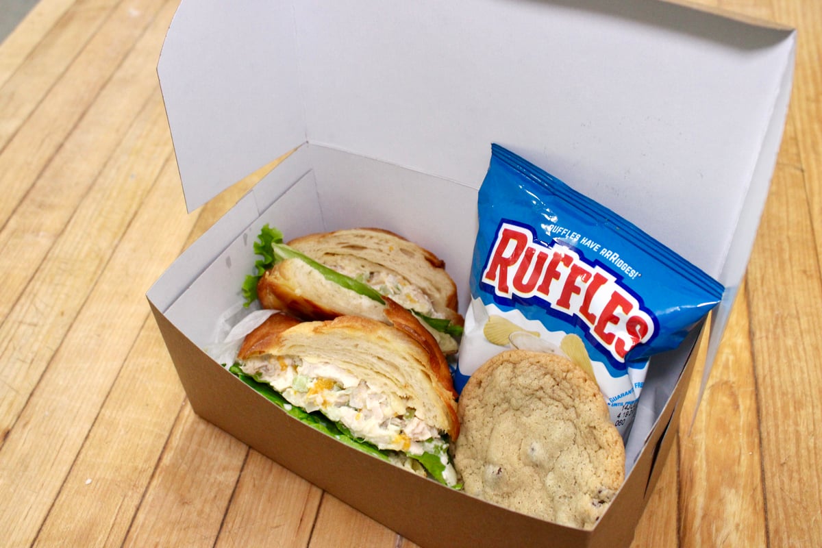 Boxed lunch with croissant sandwich and pastries from Illinois St Food Emporium