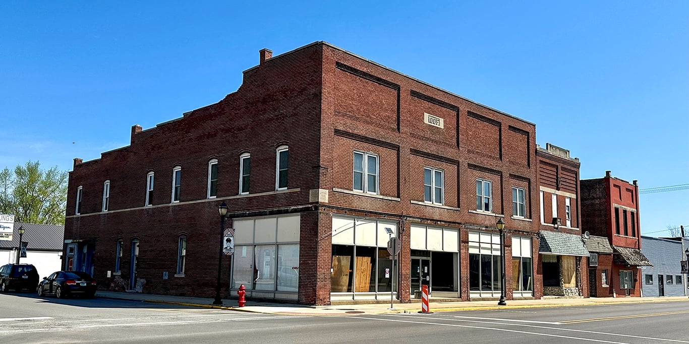 A two-story red brick IOOF building with vacant ground-floor storefronts on a downtown corner in Tipton, Indiana