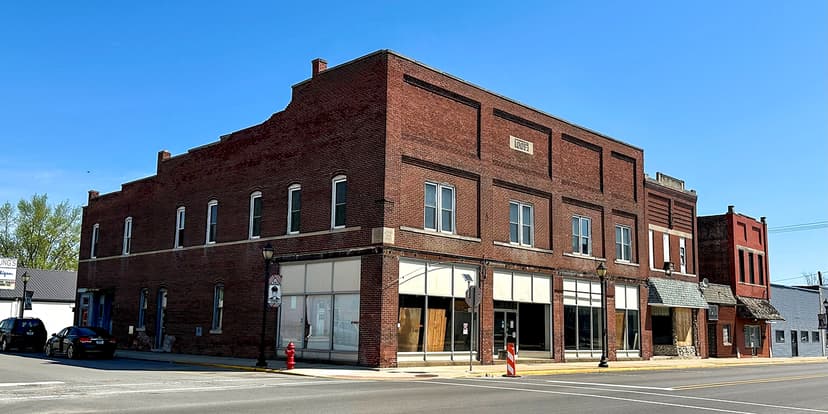 A two-story red brick IOOF building with vacant ground-floor storefronts on a downtown corner in Tipton, Indiana