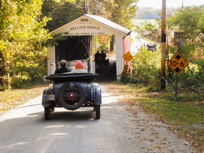 A Model T driving toward the 1896 Melcher Covered Bridge in Parke County