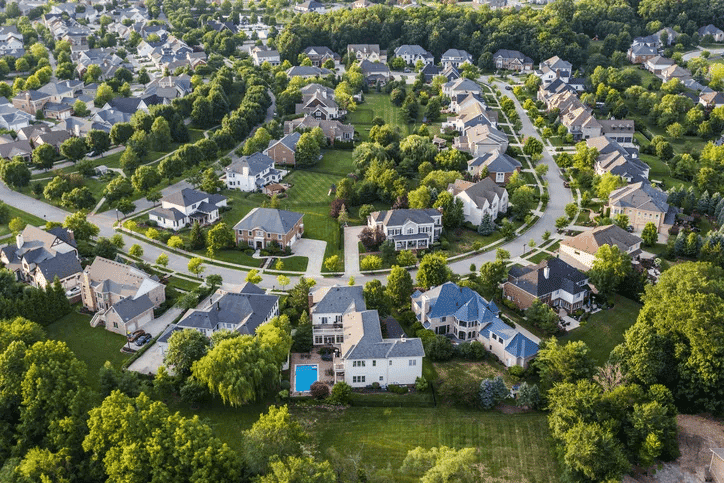 Aerial view of a leafy Indianapolis suburban neighborhood with detached family homes along curving streets