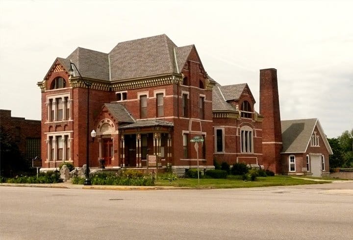 The Victorian brick exterior of the Rotary Jail Museum in Crawfordsville, Indiana, with steep gabled roofs and a tall chimney on a corner lot.