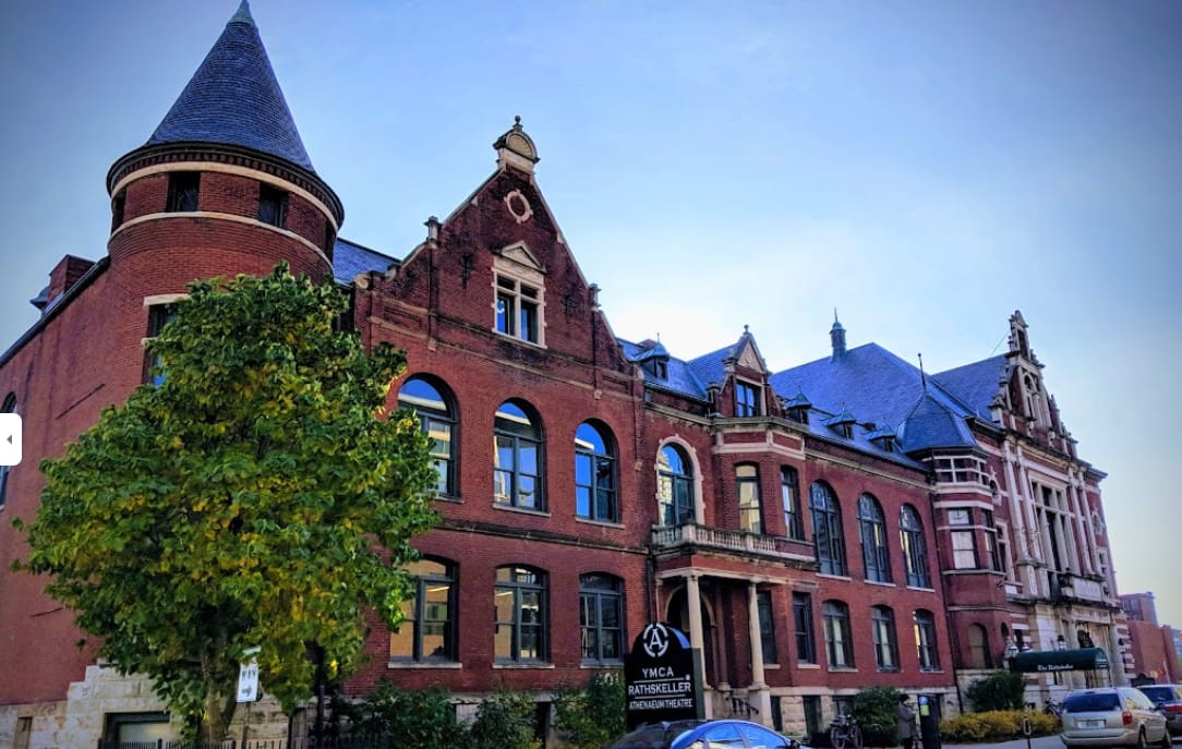 Red brick Athenaeum building on Mass Ave in Indianapolis with a round turret and a sign reading YMCA Rathskeller Athenaeum Theatre