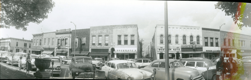 Vintage black-and-white panorama of downtown Lebanon, Indiana storefronts, including a Western Auto store, with 1950s cars parked along the street