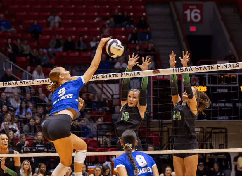 High school volleyball players competing at the net during the IHSAA state finals