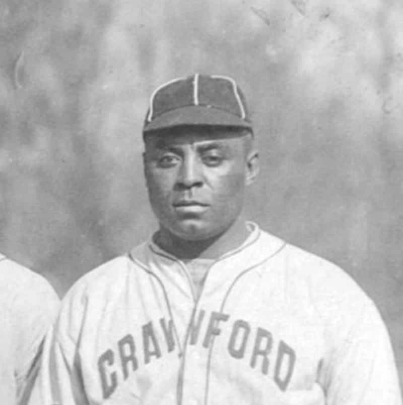 Black-and-white portrait of Oscar Charleston in a ball cap and Pittsburgh Crawfords jersey