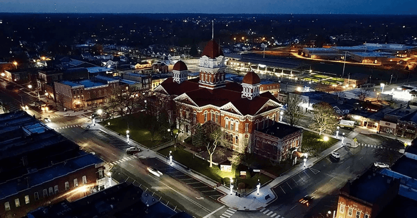 Night aerial view of a lit county-courthouse square in a downtown Indiana town